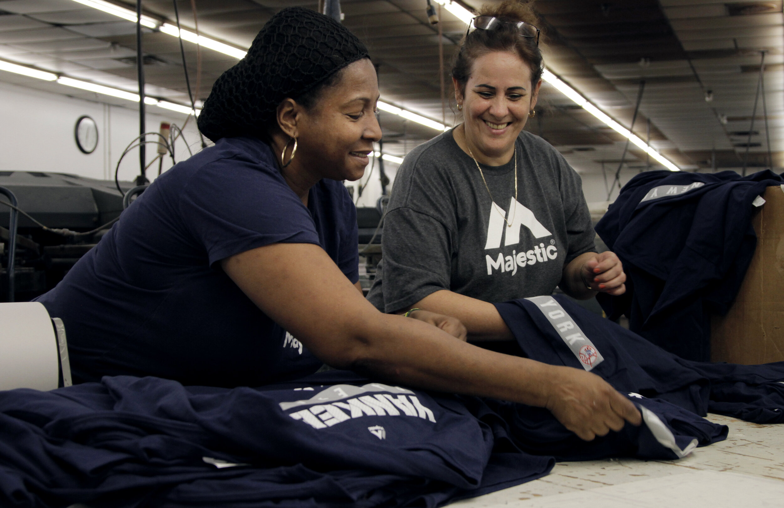 women smiling while working at screen print facility